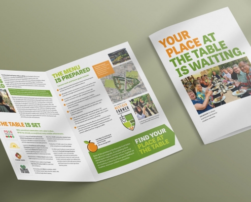 cover and interior spread of a donor brochure. Cover has photo of smiling people sitting at a community dinner table, with text above "Your Place at the table is waiting."